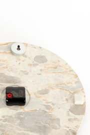 Achteraanzicht van een ronde wandklok met lichte natuursteenlook, zwart uurwerk, sleutelgatophanging en beschermende afstandhouders