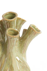 Nahaufnahme einer grünen, organisch geformten Vase mit mehreren Öffnungen und einer texturierten Oberfläche, die an Baumrinde erinnert.