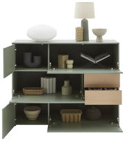 Grünes Highboard mit offenen Türen und Schubladen, dekoriert mit modernen Vasen und einer Lampe, Frontalansicht.