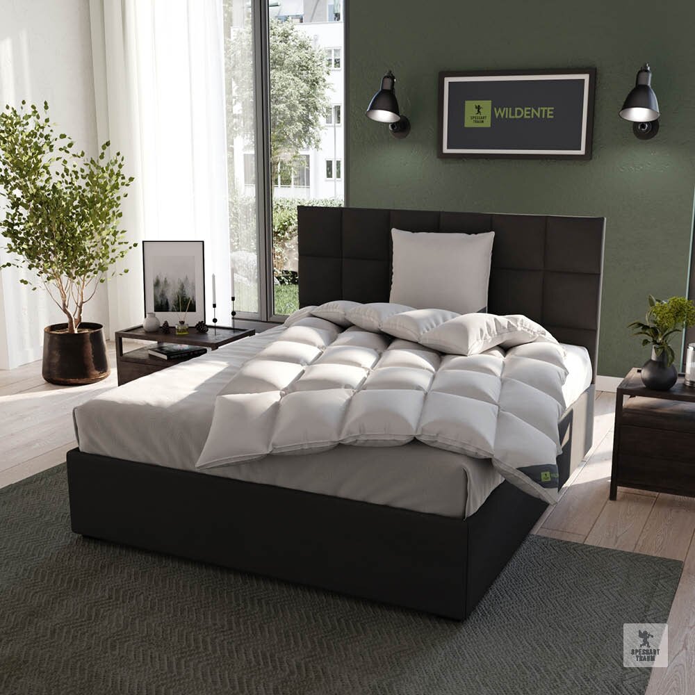 Spessarttraum Duodecke WILDENTE Gemütliches Schlafzimmer mit einem modernen Bett, das mit einer weißen, gesteppten Cassettendecke und einem passenden Kissen ausgestattet ist. Die Perspektive zeigt das Bett von schräg vorne, umgeben von stilvoller Dekoration und einem großen Fenster im H