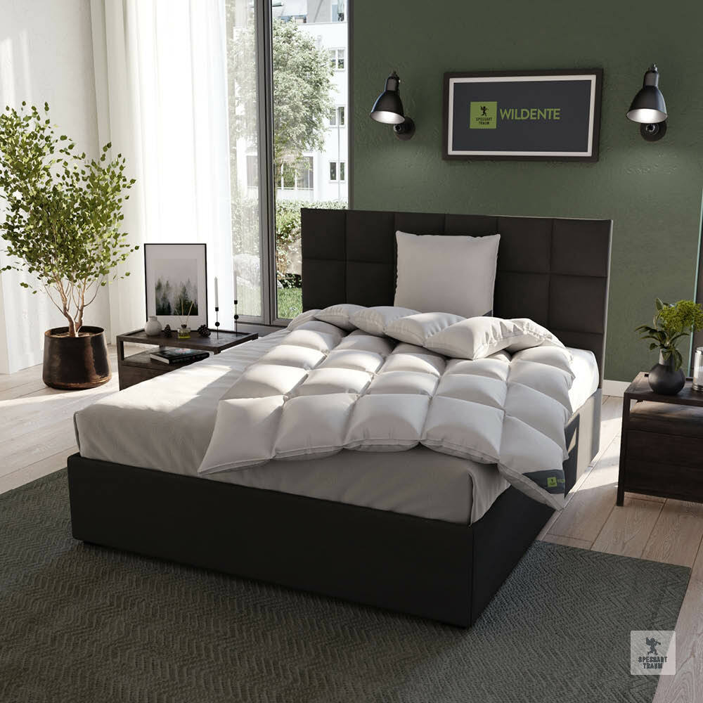 Gemütliches Schlafzimmer mit einem modernen Bett, das mit einer weißen, gesteppten Cassettendecke und einem passenden Kissen ausgestattet ist. Die Perspektive zeigt das Bett von schräg vorne, umgeben von stilvoller Dekoration und einem großen Fenster im H