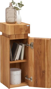 Beistelltisch aus Holz der Serie MAYA von Linea Natura, mit geöffneter Tür, Bücher und Dekoration darauf, aus seitlicher Perspektive.