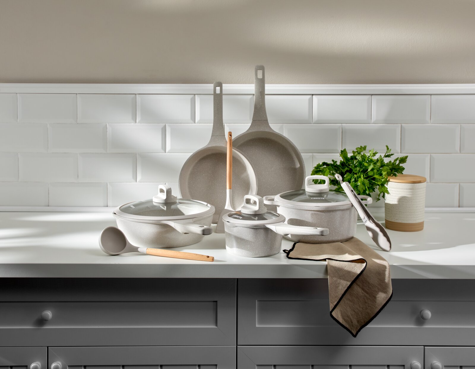 Een achtdelige pannenset in een moderne keuken, gefotografeerd vanuit de voorkant.