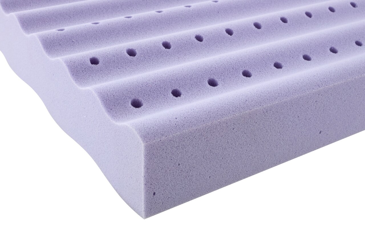 Nahaufnahme einer lila Jugendmatratze mit wellenförmiger Oberfläche und Belüftungslöchern, seitliche Perspektive