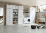 Moderne weiße Schrankwand mit Regalen und Aufbewahrungsmöglichkeiten in einem hellen Raum, seitliche Perspektive