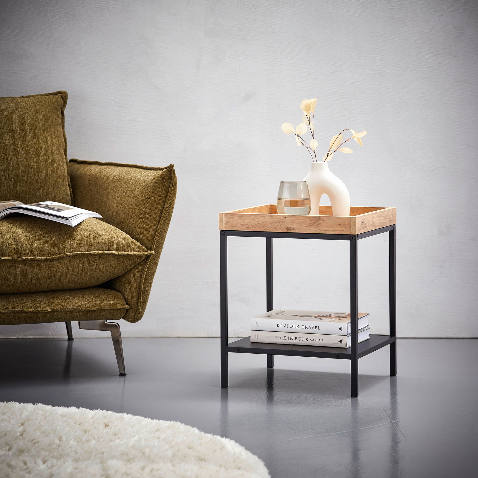 Moderner Beistelltisch mit Holzplatte und schwarzem Metallgestell, seitliche Perspektive, dekoriert mit Vase und Glas.