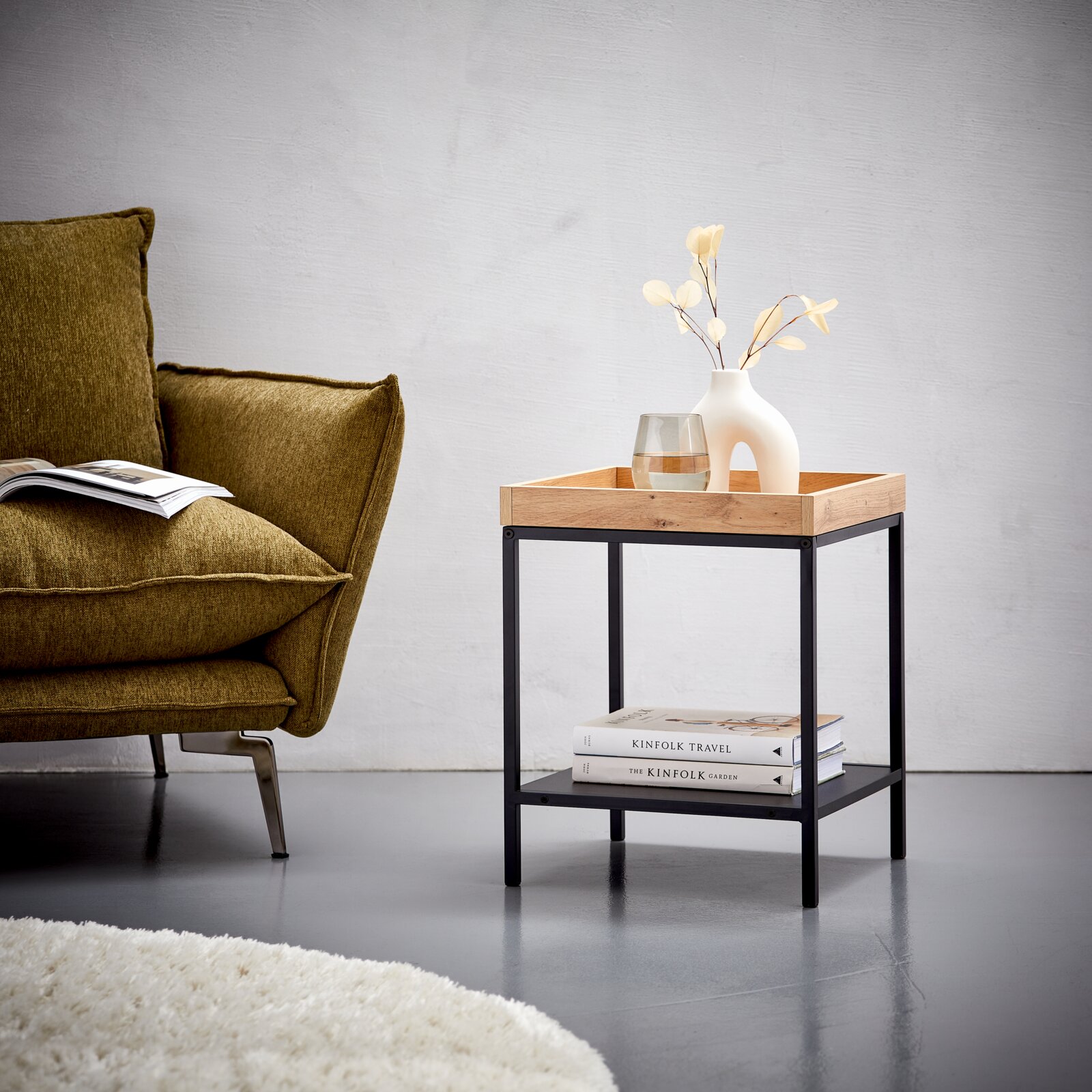Moderner Beistelltisch mit Holzplatte und schwarzem Metallgestell, seitliche Perspektive, dekoriert mit Vase und Glas.