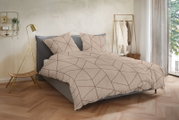 Beige Bettwäsche mit geometrischem Linienmuster in Braun auf einem grauen Polsterbett, frontal in leichter Schrägansicht von vorn fotografiert, im hellen Schlafzimmer mit goldener Stehlampe und Kleiderständer.