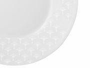 Nahaufnahme eines weißen Speisetellers mit dezentem Muster am Rand, von oben betrachtet.