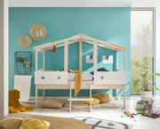 Spielbett in Hausform aus hellem Holz mit weißem Geländer, dekoriert mit Kissen und Decken, in einem Kinderzimmer mit türkisfarbener Wand. Perspektive: Frontalansicht.