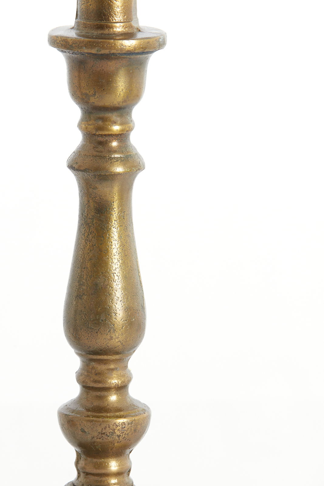 Nahaufnahme eines antik wirkenden, goldfarbenen Lampenfußes mit dekorativen Verzierungen.