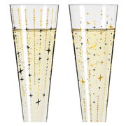 Zwei Champagnergläser mit goldenen und schwarzen Sternmustern, gefüllt mit sprudelndem Getränk, frontal betrachtet.