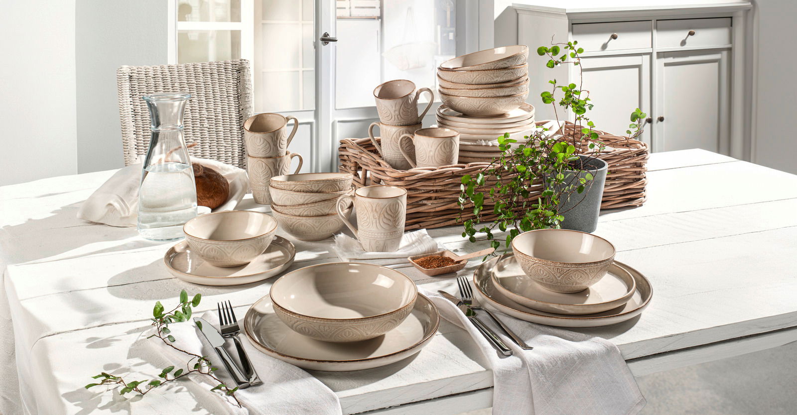 Kombiservice 30-teilig in beige mit elegantem Muster, arrangiert auf einem gedeckten Tisch in heller, einladender Umgebung. Perspektive von vorne.