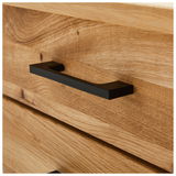 Nahaufnahme eines Schreibtischs aus Holz mit einer schwarzen Griffleiste, seitliche Perspektive