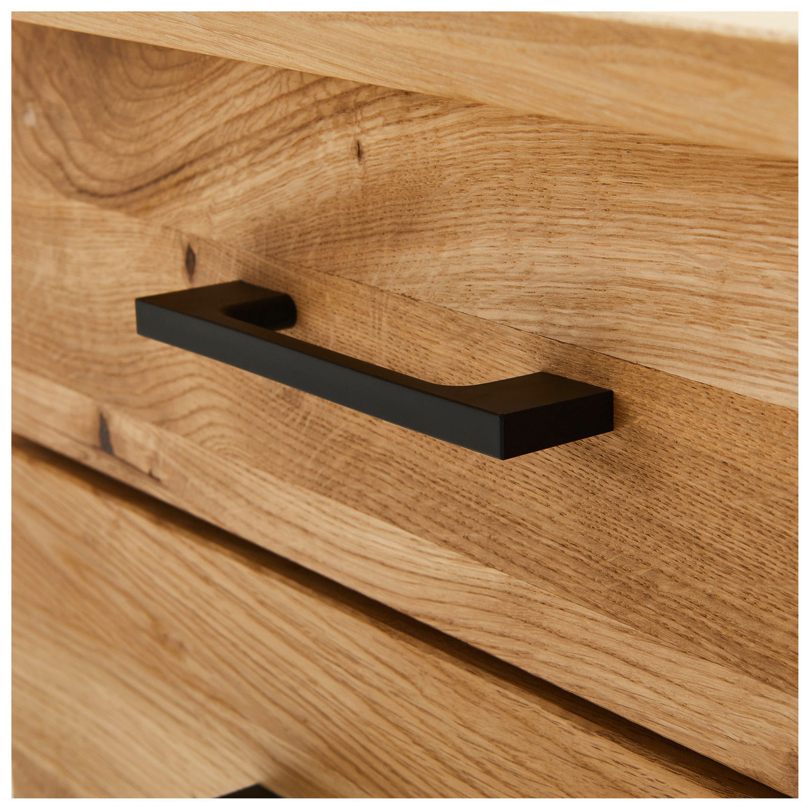 Nahaufnahme eines Schreibtischs aus Holz mit einer schwarzen Griffleiste, seitliche Perspektive