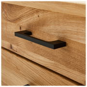 Nahaufnahme eines Schreibtischs aus Holz mit einer schwarzen Griffleiste, seitliche Perspektive