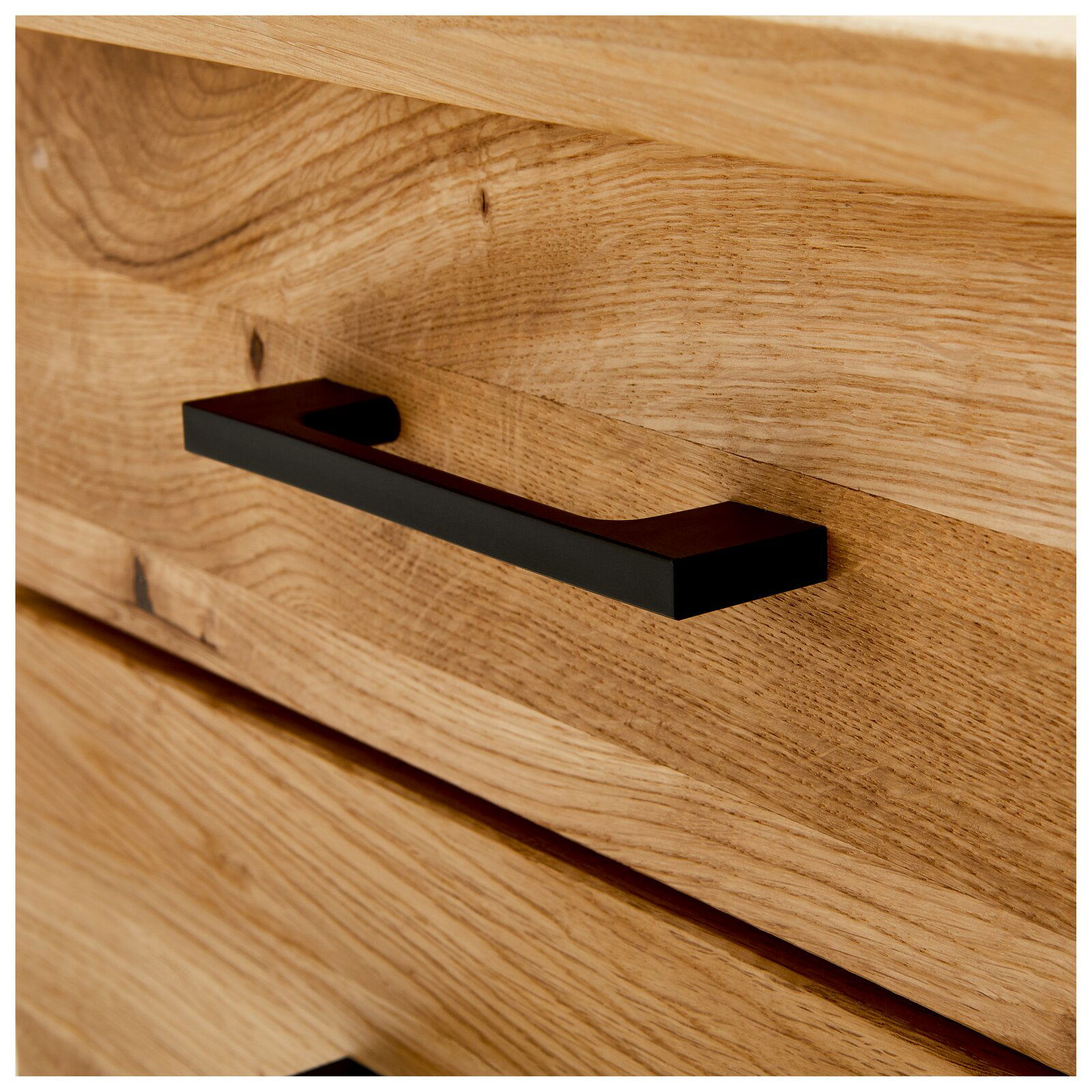 Nahaufnahme eines Schreibtischs aus Holz mit einer schwarzen Griffleiste, seitliche Perspektive