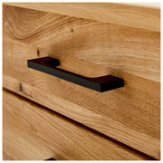 Nahaufnahme eines Schreibtischs aus Holz mit einer schwarzen Griffleiste, seitliche Perspektive