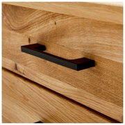 Nahaufnahme eines Schreibtischs aus Holz mit einer schwarzen Griffleiste, seitliche Perspektive