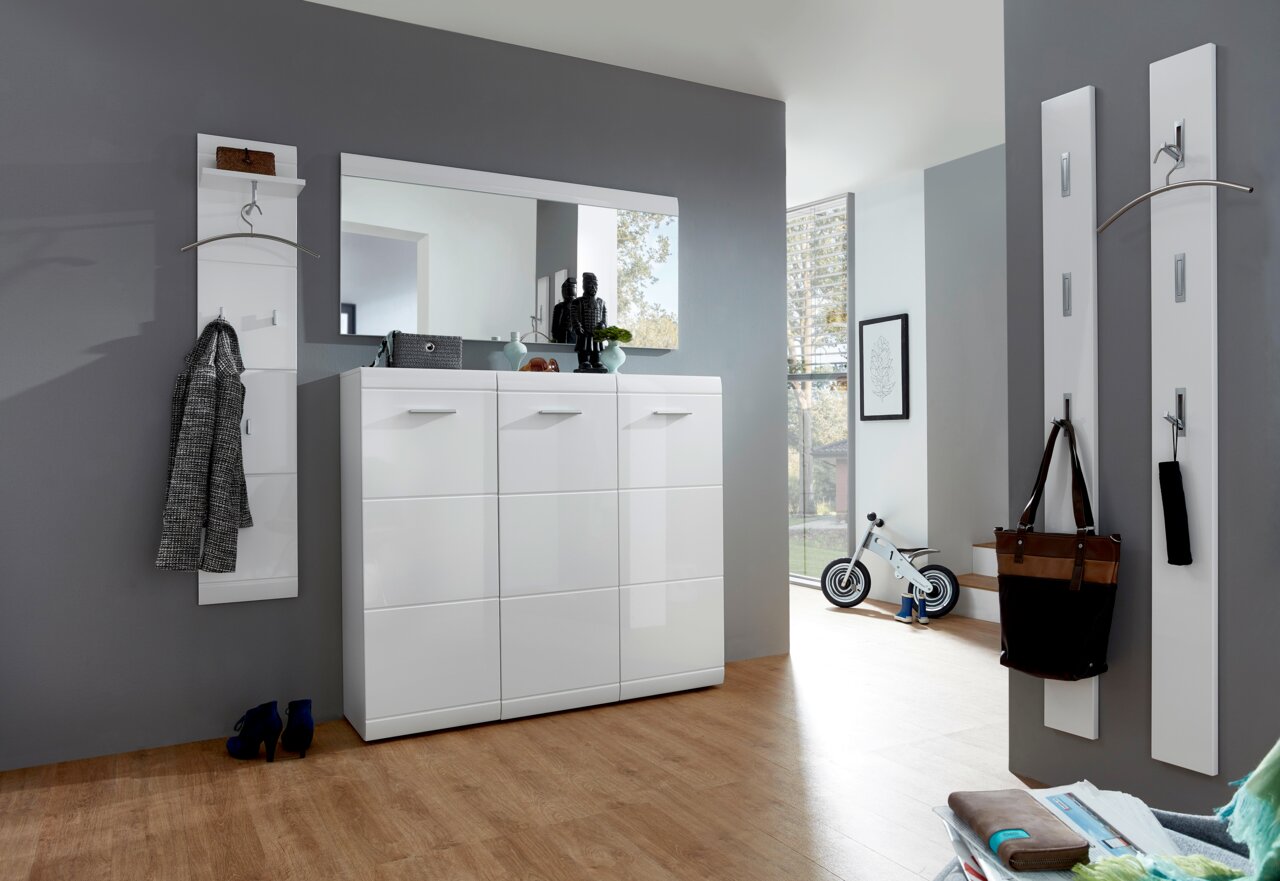 Moderner Eingangsbereich mit weißem Hochglanz-Schuhschrank, großem Spiegel und Garderobenpaneelen, seitliche Perspektive.
