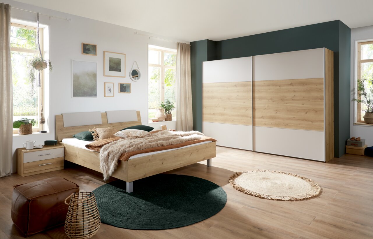 Schlafzimmer mit Futonbett und Schwebetürenschrank in Holzoptik, seitliche Perspektive