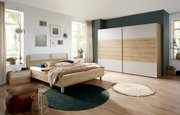 Schlafzimmer mit Futonbett und Schwebetürenschrank in Holzoptik, seitliche Perspektive