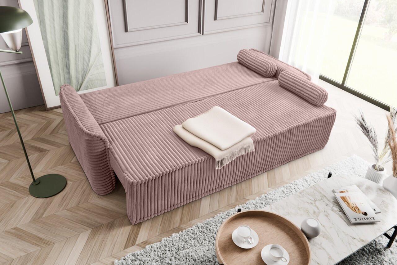 Schlafsofa 3 Sitzer in rosa Cordstoff, von oben fotografiert, mit zwei Kissen und einer gefalteten Decke.