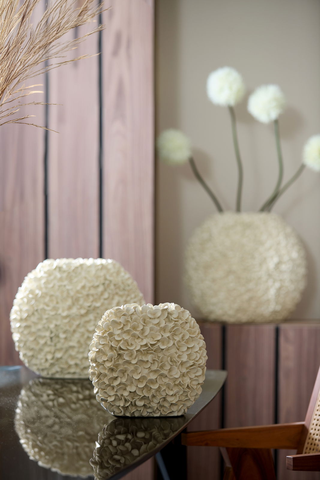 Light&Living Vase PHYLIA Nahaufnahme einer dekorativen Vase mit blütenförmiger Struktur auf einem Tisch, im Hintergrund weitere Vasen und Dekorationen.