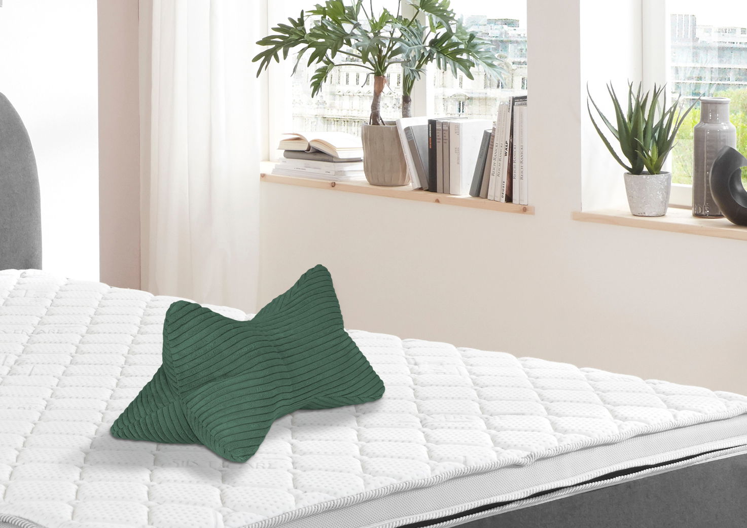 Grüner Leseknochen auf einem weißen Bett, seitliche Perspektive