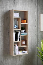 Wandregal aus hellem Holz mit versetzten Fächern, frontal aus leichter Schrägperspektive an einer Betonwand fotografiert, dekoriert mit Büchern, Glasgefäß, Pflanze und kleiner Uhr.