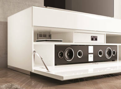 Weißes TV-Lowboard mit offener Klappe, zeigt integriertes Soundsystem und Ablagefächer, seitliche Perspektive.