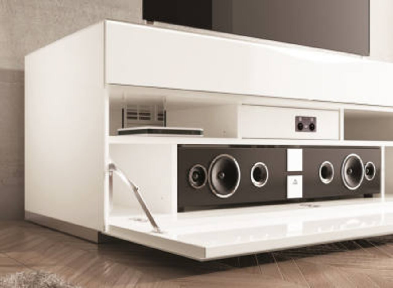 Weißes TV-Lowboard mit offener Klappe, zeigt integriertes Soundsystem und Ablagefächer, seitliche Perspektive.