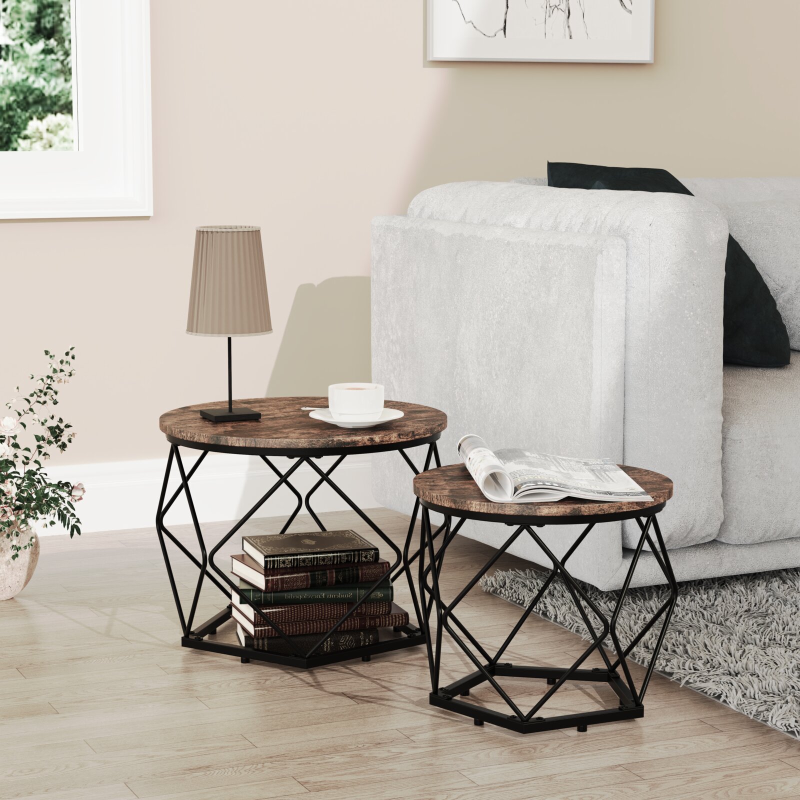 VCM Beistelltisch 2er Set HELARO Wohnzimmer-Szene mit zwei runden Beistelltischen aus dunkler Holzoptik und schwarzem Metallgestell neben einem hellen Sofa, fotografiert in seitlicher Perspektive leicht von vorne; auf den Tischen stehen Lampe, Tasse und Magazin.