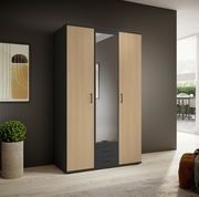 Drehtürenschrank mit drei Türen, mittlere Tür mit Spiegel, in einem modernen Raum mit Holzboden und dekorativer Wand. Perspektive von vorne links.