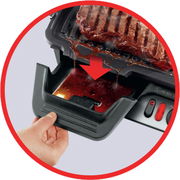 Nahaufnahme eines Kontaktgrills mit abtropfendem Fett in eine Auffangschale.