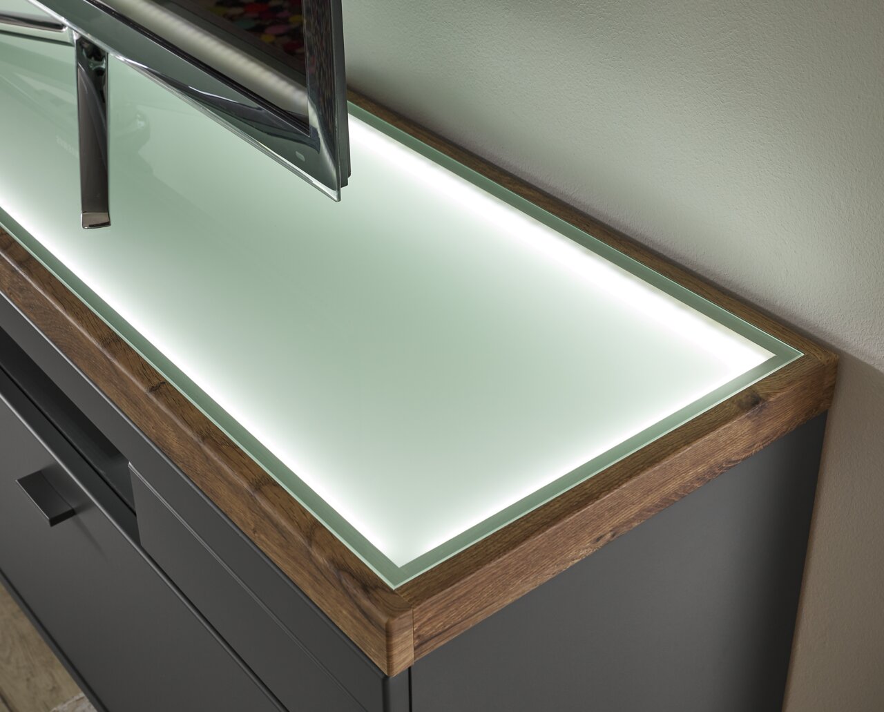 TV-Lowboard mit Glasoberfläche und Holzrahmen, seitliche Perspektive