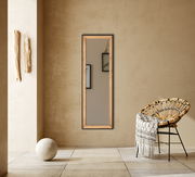 Rechteckiger Spiegel mit Holzrahmen, an einer beigen Wand hängend, mit einem modernen Stuhl und Dekoration im Vordergrund, seitliche Perspektive.