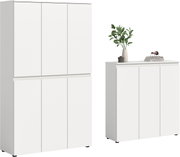 Zwei weiße, grifflose Schränke (Hochschrank und Sideboard) mit glatten Fronten, freigestellt auf weißem Hintergrund, in frontaler Perspektive; auf dem Sideboard stehen Vase mit grünen Zweigen und Bücher.