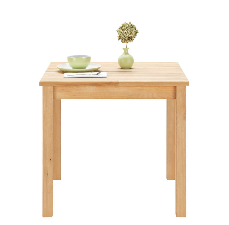 Esstisch aus Holz mit quadratischer Tischplatte, darauf eine grüne Vase mit Pflanze und ein grünes Geschirrset, frontale Perspektive