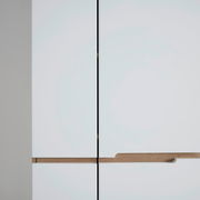 Nahaufnahme eines modernen weißen Garderobenschranks mit Holzgriffen, Frontalansicht