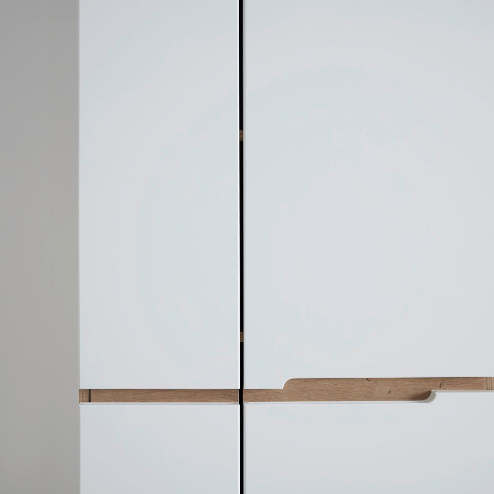 Nahaufnahme eines modernen weißen Garderobenschranks mit Holzgriffen, Frontalansicht