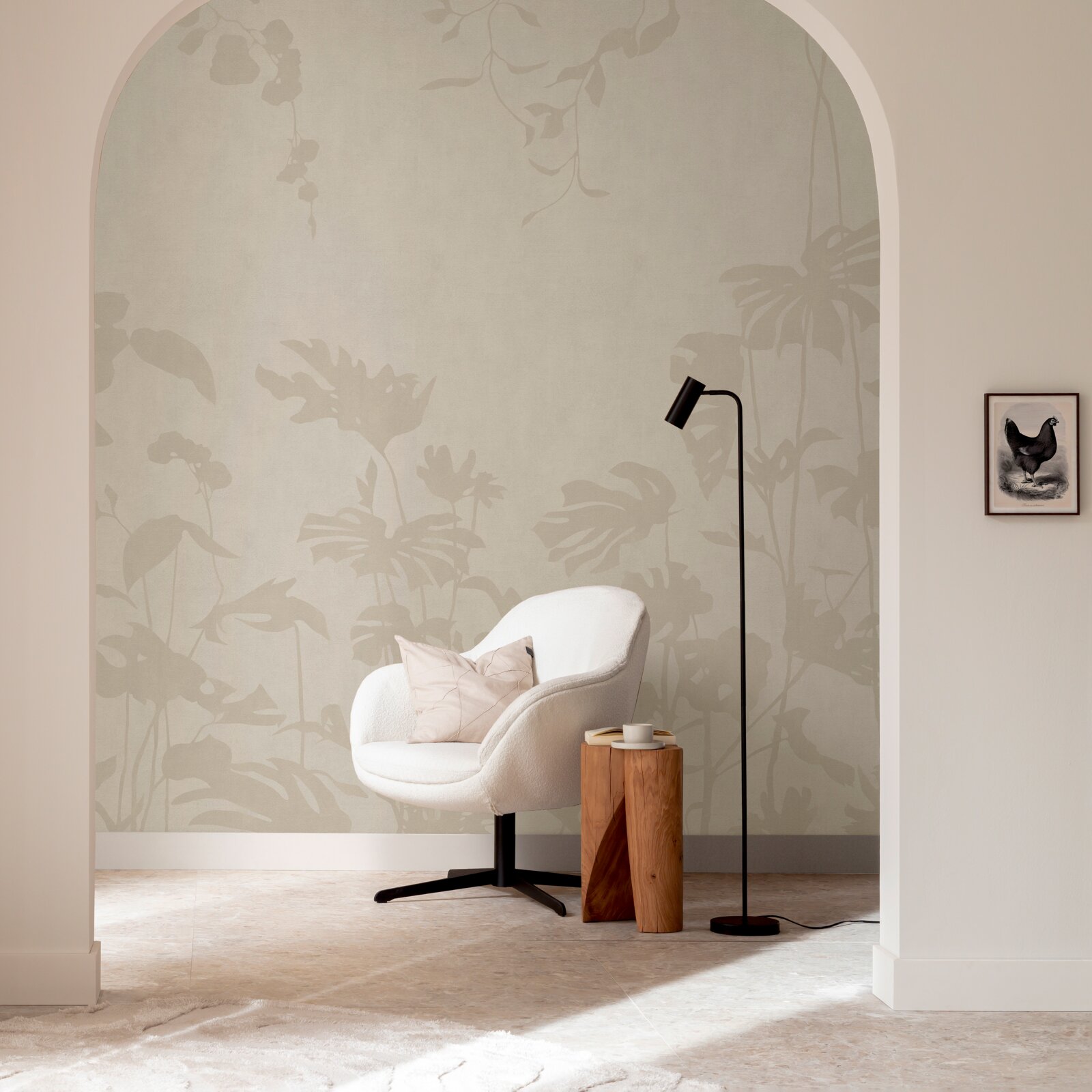 Beige Tapete mit dezentem botanischem Blattmuster im modernen Wohnzimmer-Setting, frontale Perspektive; davor weißer Sessel, schwarzer Stehlampe und kleiner Holzhocker.