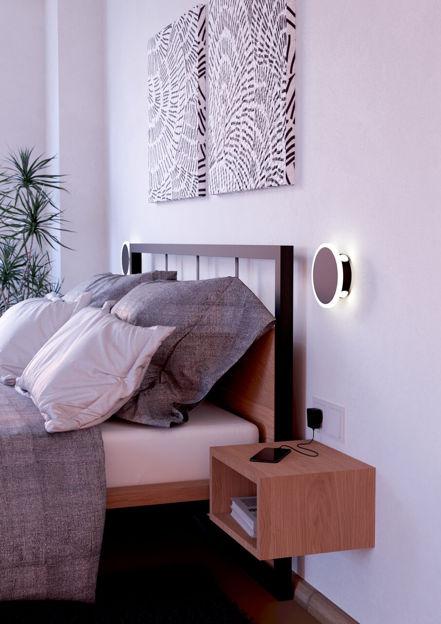 Moderne Wandleuchte TALAMELLO 1 neben einem Bett, seitliche Perspektive