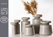 Sechs graue Vasen der Serie Imperia aus Steingut mit Reaktivglasur, in verschiedenen Größen, von vorne betrachtet. Eine Vase ist mit getrockneten Gräsern dekoriert.