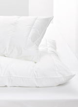 Weißes Kopfkissen auf einem Bett, seitliche Perspektive