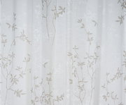 Nahaufnahme eines weißen Vorhangs mit zartem, floralen Muster in Beige, frontal betrachtet.