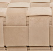 Nahaufnahme eines beigen Hockers mit Stauraum, der ein geflochtenes Textilmuster zeigt.