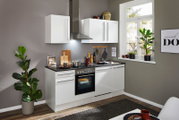 Moderne weiße Küchenzeile ohne Elektrogeräte, mit Blick auf die Arbeitsfläche und Hängeschränke, in einem stilvoll eingerichteten Raum mit Pflanzen und Dekoration.