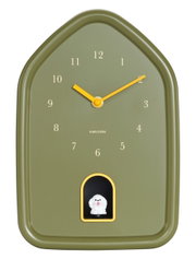 Grüne Wanduhr in Hausform mit gelben Zeigern und einer kleinen weißen Hundefigur in einer Öffnung unten, Frontalansicht