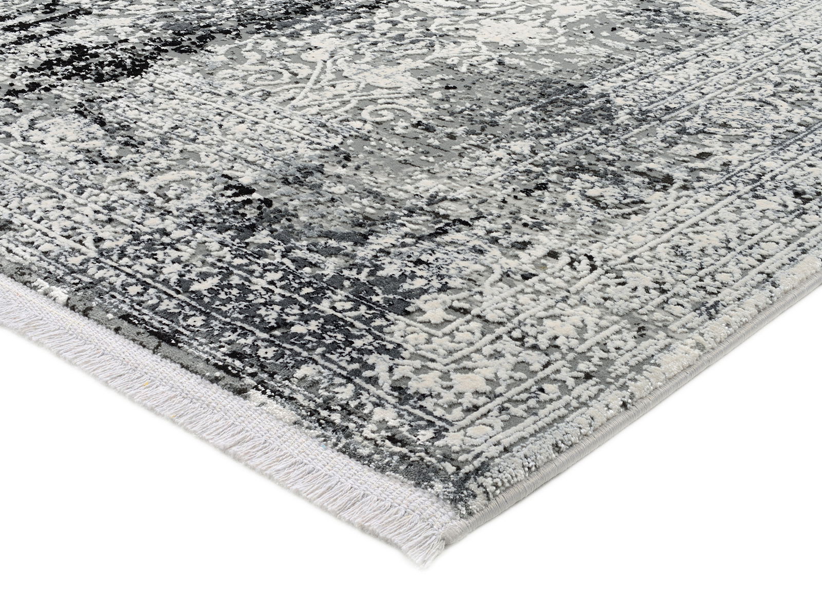 Nahaufnahme eines Designer-Teppichs mit grauem und weißem Muster, perspektivisch von der Seite aufgenommen.